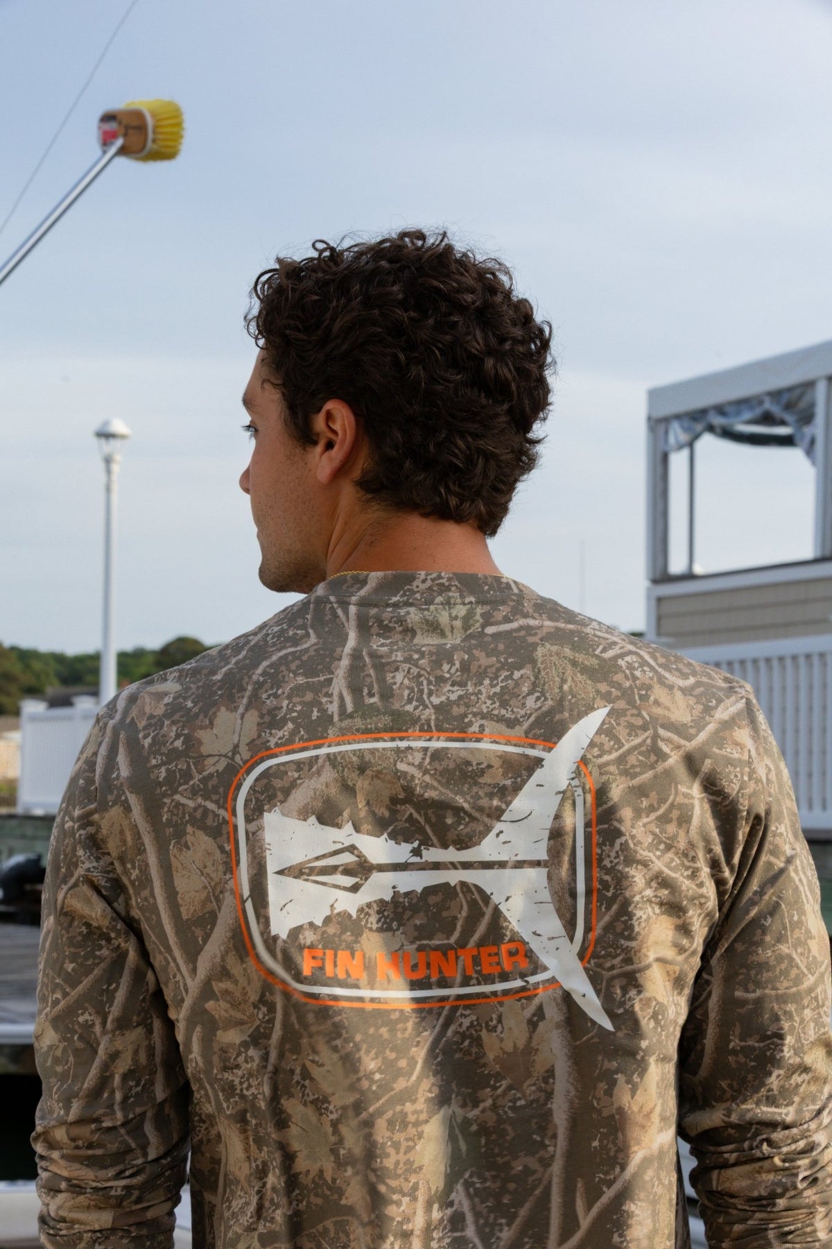 Man wearing Fin Hunter Tuna Tail Deadwood Camo Long Sleeve, back view